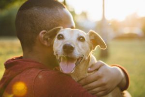 rear view of a young man hug his small dog